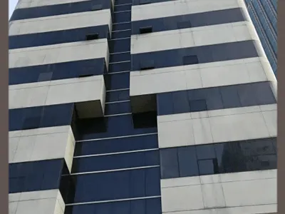 南京住建委大楼全景，灰色石材与深蓝玻璃幕墙立面