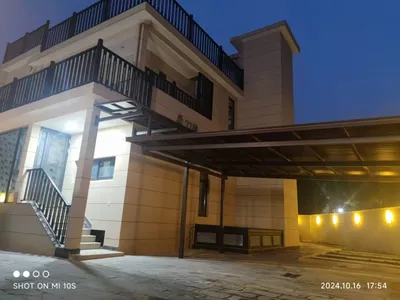 钢结构厂房屋面施工，九名作业人员身穿红色工装佩戴蓝色安全帽在场中作业
